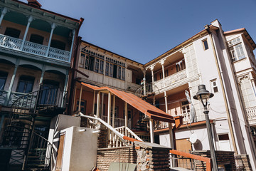 01.06.2019 Tbilisi, Georgia: view of old stone houses with beautiful colored roofs in the center of the old town where tourists are walking