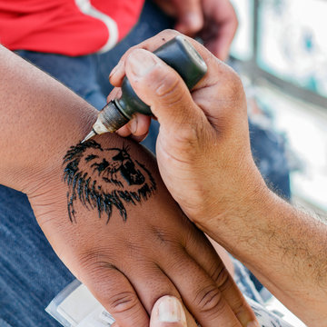 tattoo master applies henna tattoo