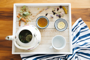 Autumn hot herbal tea with honey, cinnamon and lemon. Top view. Image toned.
