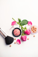 Obraz na płótnie Canvas Professional makeup tools with pink flowers flatlay on white background