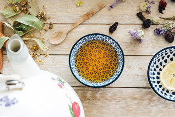 Autumn hot herbal tea with honey, cinnamon and lemon. Top view. Image toned.