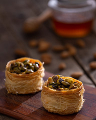 arabic sweets, nuts and honey pot in a wood table