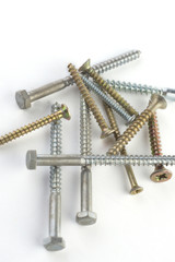  silver and gold screws on a white background, close-up
