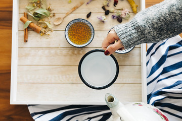 Autumn hot herbal tea with honey, cinnamon and lemon. Top view. Image toned.