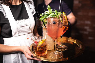 Girl holding cocktail  in the restaurant. Alcoholic drinks.