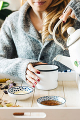 Pouring tea into a cup. Autumn hot herbal tea with honey, cinnamon and lemon. Top view. Image toned.