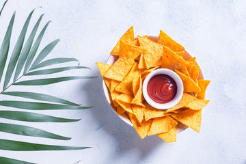 Traditional mexican snack nachos with sauce and palm branch on a white background