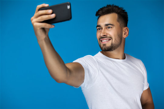 Handsome american man takes a selfie and smiles at the camera