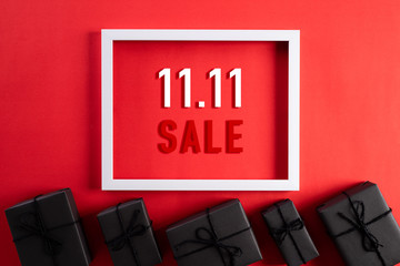 Online shopping of China, 11.11 singles day sale concept. Top view of white picture frame with black gift box on red background with copy space for text 11.11 singles day sale.