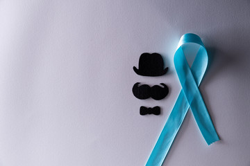 Blue ribbon with the growing of moustaches on white background representing an annual event during...