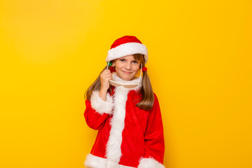 Child in Santa costume putting on party glasses