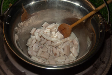 fried bacon in a stainless steel pan