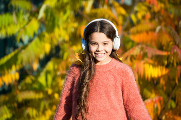 Music for autumn mood. Kid girl relaxing near autumn tree with headphones. Listening song. Enjoy...