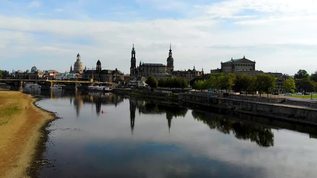 Aerial flying over River Elbe, view of the city center of Dresden, Germany. Famous Baroque-style architecture buildings are reflected in the water. Aerial shot taken by drone