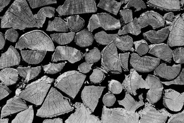 Brennholzstapel als Hintergrund und Textur in schwarz weiß