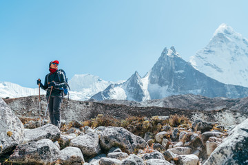 Jonge backpacker-vrouw die remt tijdens het wandelen en geniet van de vallei tijdens de Everest Base Camp-route op grote hoogte in de buurt van Dingboche, Nepal. Ama Dablam 6812m op de achtergrond. Actief vakantieconcept