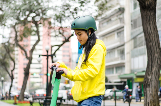 Young Woman With Helmet On An Electric Scooter In The City