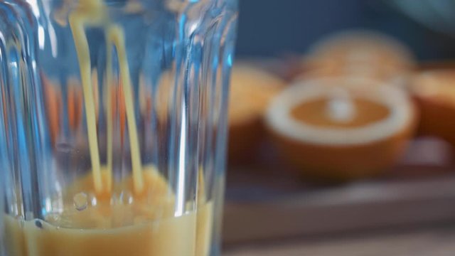 Pouring freshly squeezed orange juice into glass