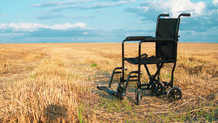 Empty wheelchair in a wide meadow. disabled carriage in nature. medical equipment for invalid person