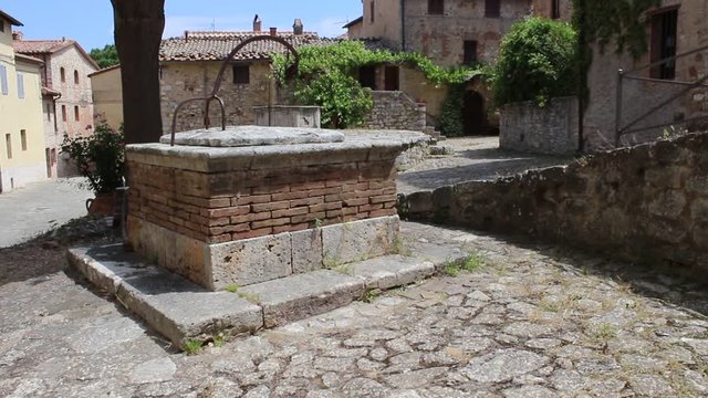  Tilt up view of the Cisterna square with the little well in the village of Rocca D Orcia, Tuscany, Italy