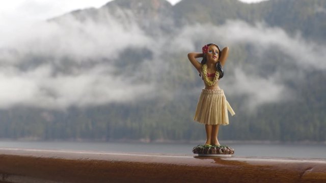 Hula dancer hawaii souvenir girl doll on Alaska cruise ship deck travel trip - funny vacation concept background. Autumn Alaska holiday.