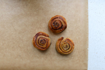 Homemade cinnamon rolls on a parchment paper. Top view.