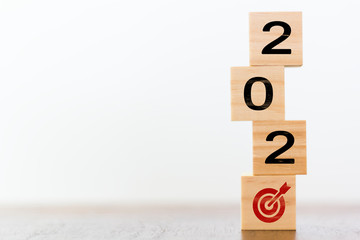2020 on wooden cubes with goal target. Concept of successful new year resolutions