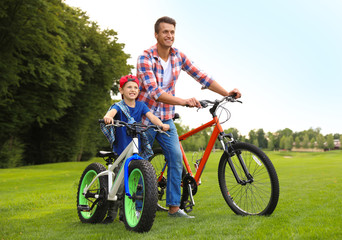 Fototapeta premium Dad and son with modern bicycles outdoors