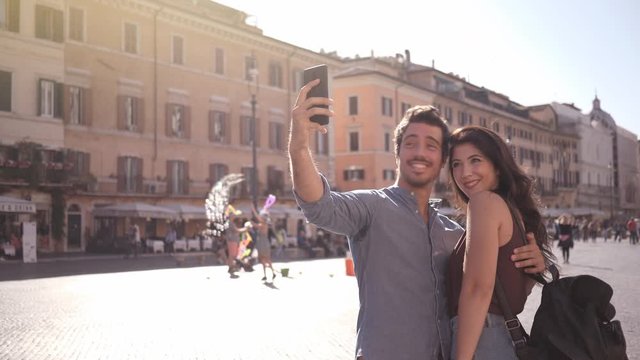 A cute couple taking pictures in Rome and looking at them