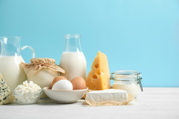 Different dairy products on white table against blue background