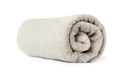 Rolled clean beige towel on white background