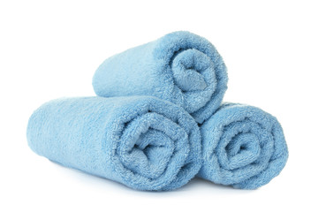 Fototapeta na wymiar Rolled clean turquoise towels on white background