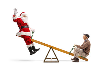 Santa Claus waving and playing on a seesaw with a senior man