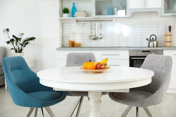 Stylish room interior with dining table and chairs