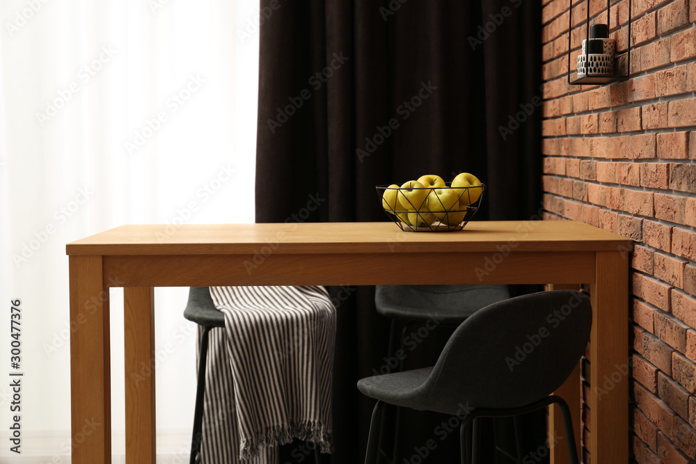 Poster Elegant room interior with wooden table near brick wall