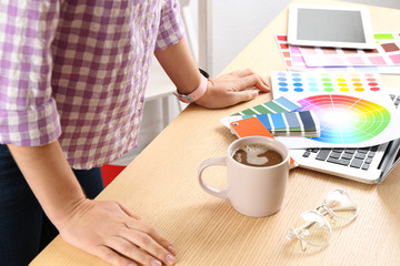Woman working with palette samples at wooden table, closeup