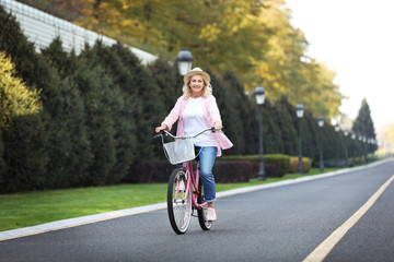 Mature woman riding bicycle outdoors. Active lifestyle