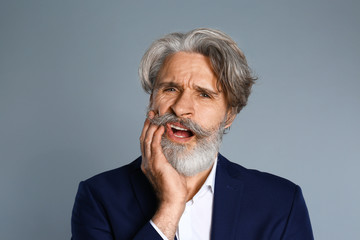 Obraz premium Man suffering from toothache on grey background