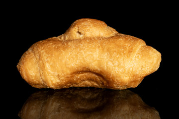 One whole fresh baked mini croissant isolated on black glass