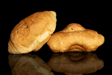 Group of two whole fresh baked mini croissant isolated on black glass