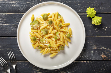 Penne pasta with romanesco cabbage on darck wooden background