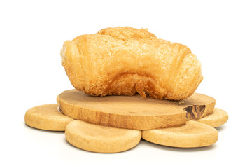 One whole fresh baked mini croissant on tree stump isolated on white background