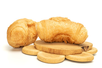 Group of two whole fresh baked mini croissant on tree stump isolated on white background