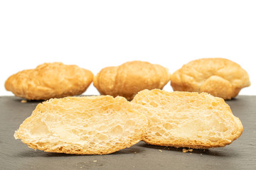 Group of three whole two halves of fresh baked mini croissant on grey stone isolated on white background
