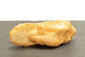 Group of two halves of fresh baked mini croissant on grey stone isolated on white background