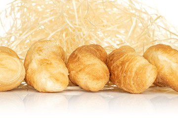 Group of five whole fresh baked mini croissant with straw isolated on white background