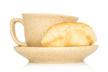 One whole fresh baked mini croissant with cup isolated on white background