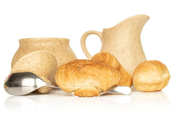 Group of three whole fresh baked mini croissant with sugar bowl , ceramic jug and steel spoon isolated on white background