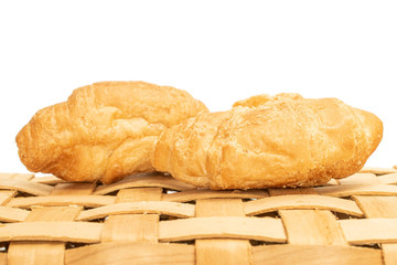 Group of two whole fresh baked mini croissant on bast basket isolated on white background