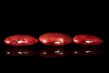 Group of three whole fresh red kidney beans isolated on black glass